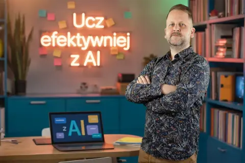 Mężczyzna w koszuli stoi na tle biurka z laptopem i neonu z napisem "Ucz efektywniej z AI".